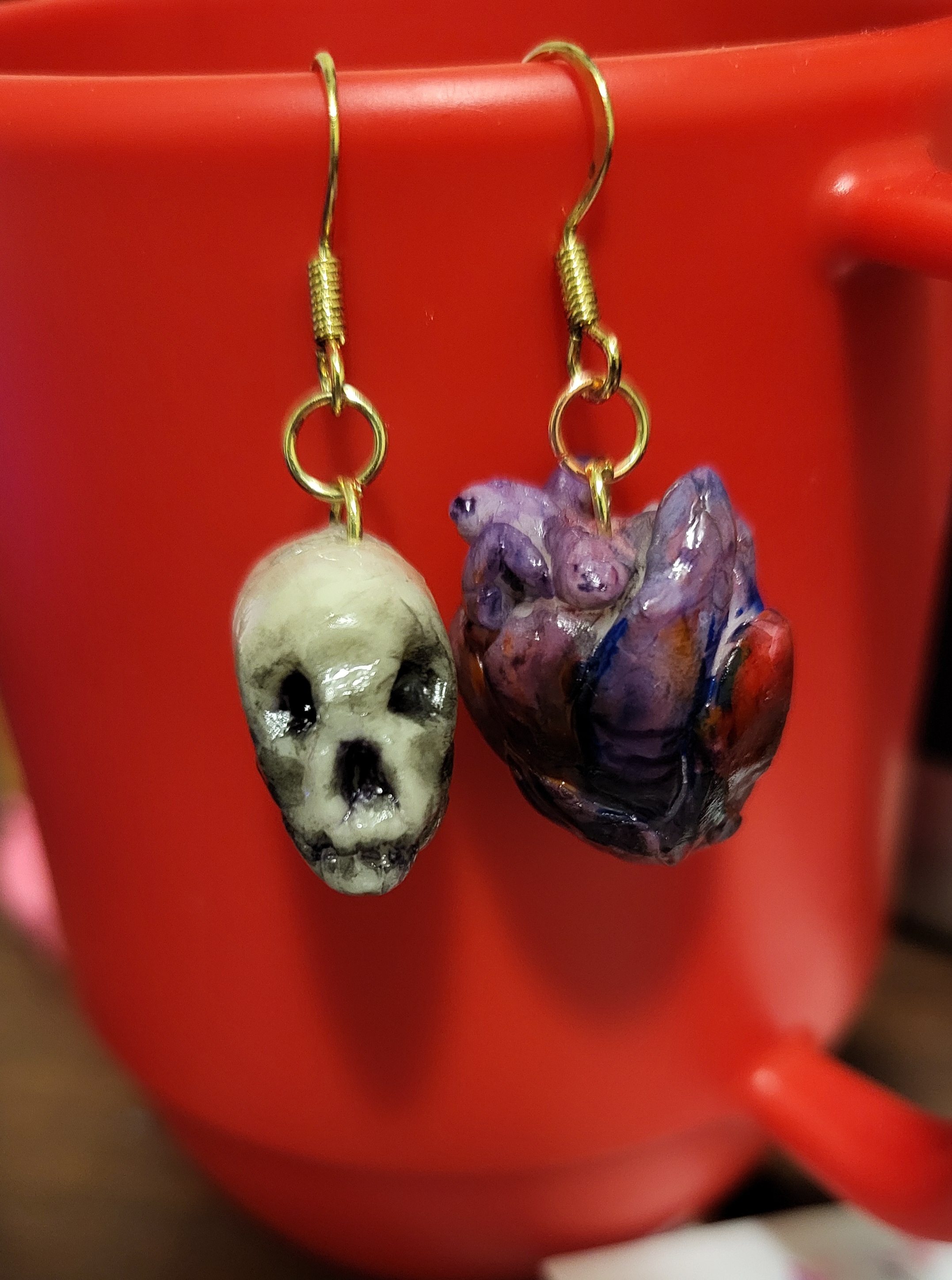Clay earrings of a skull and an anatomical heart